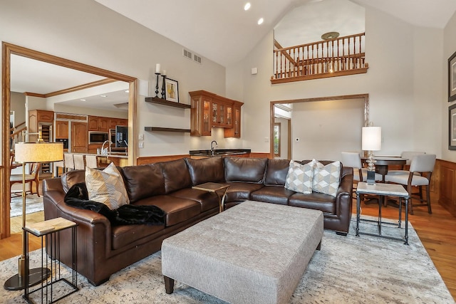 living area with light wood-style floors, visible vents, high vaulted ceiling, and recessed lighting