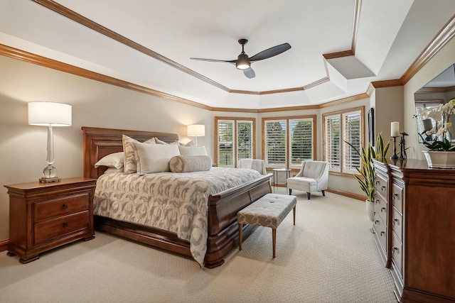 bedroom featuring light carpet, a tray ceiling, multiple windows, and baseboards