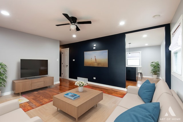 living room featuring hardwood / wood-style floors and ceiling fan