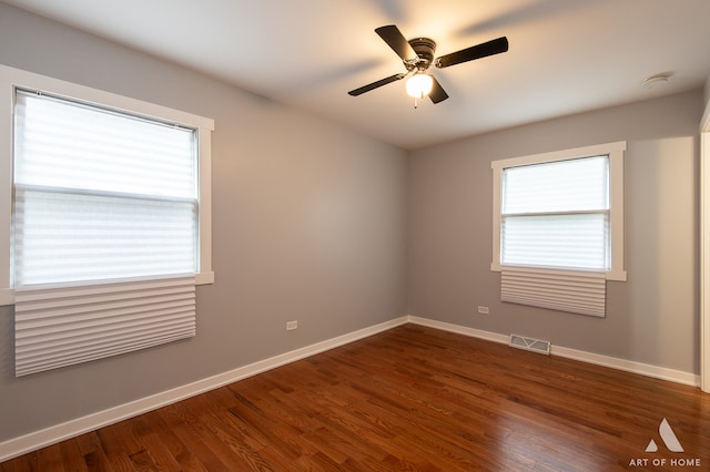 empty room with dark wood-type flooring and ceiling fan