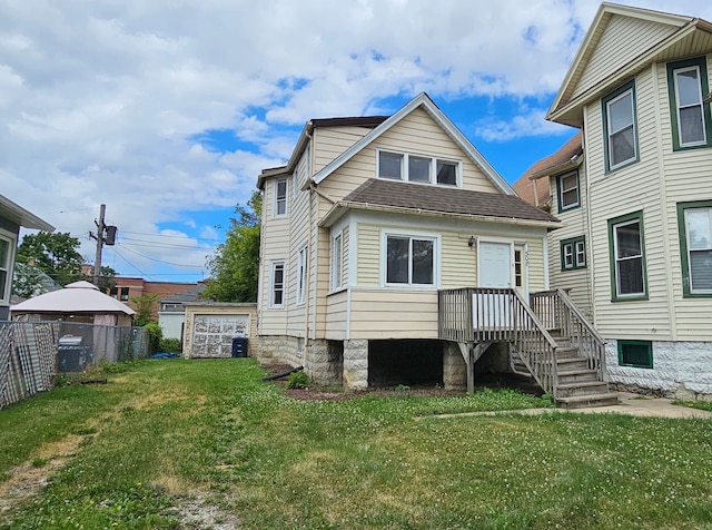 rear view of house with a yard, an outbuilding, and central AC unit