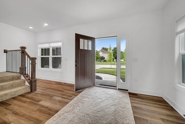 entryway featuring stairs, recessed lighting, baseboards, and wood finished floors