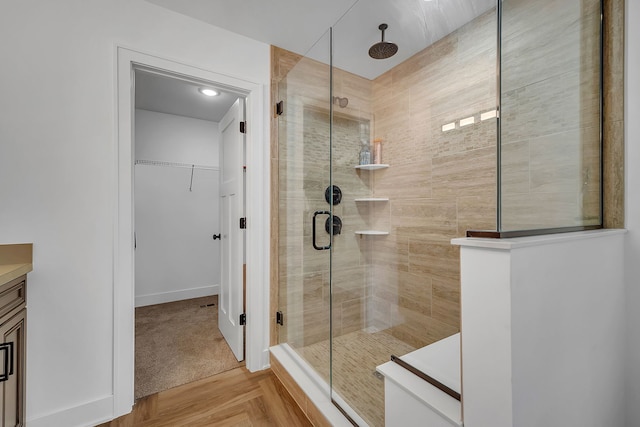 bathroom with walk in shower, vanity, and parquet floors