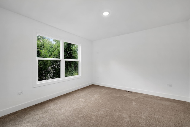 carpeted empty room featuring visible vents, baseboards, and recessed lighting