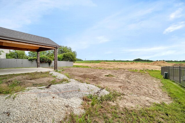 view of yard with a rural view and a patio area