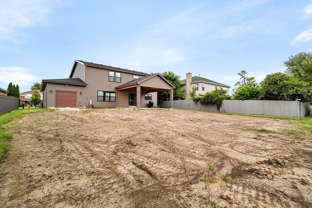 rear view of house featuring a garage