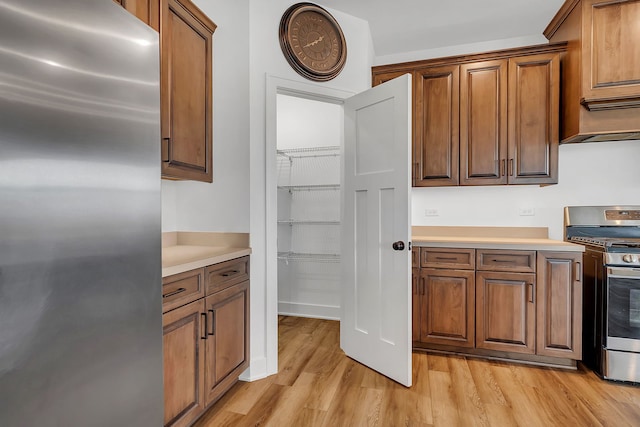 kitchen with light hardwood / wood-style floors and appliances with stainless steel finishes