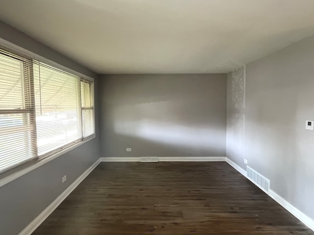 unfurnished room with dark hardwood / wood-style flooring