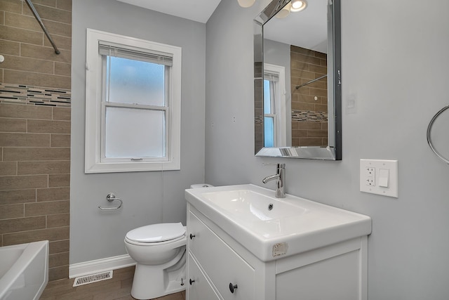 full bathroom featuring toilet, tiled shower / bath combo, vanity, and wood-type flooring