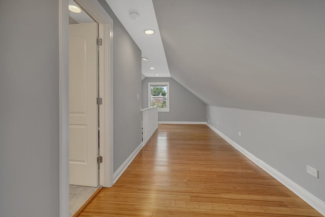 bonus room with vaulted ceiling and light hardwood / wood-style flooring