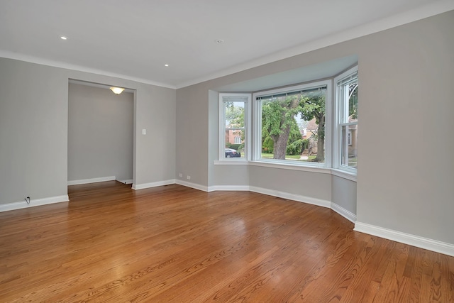 spare room featuring hardwood / wood-style floors and ornamental molding