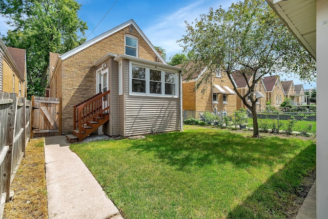 rear view of property featuring a lawn