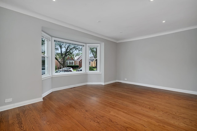 empty room featuring crown molding and hardwood / wood-style floors