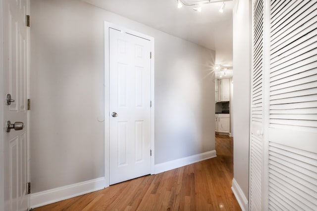 corridor featuring hardwood / wood-style floors and rail lighting