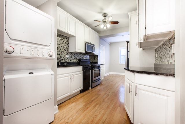 kitchen with light hardwood / wood-style flooring, ceiling fan, white cabinetry, stacked washing maching and dryer, and stainless steel appliances