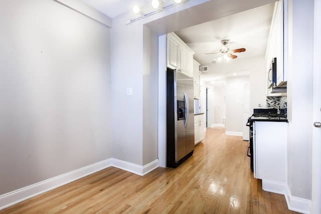 kitchen featuring light hardwood / wood-style flooring, stainless steel appliances, white cabinetry, ceiling fan, and decorative backsplash