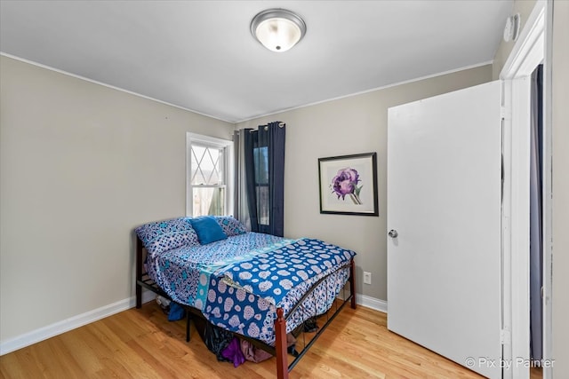 bedroom with hardwood / wood-style flooring and crown molding