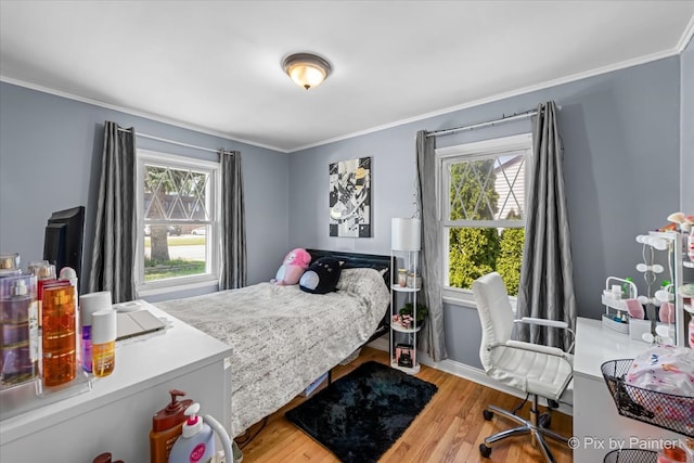 bedroom featuring multiple windows, crown molding, and light hardwood / wood-style floors