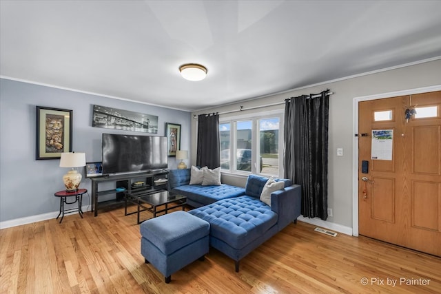 living room with ornamental molding and wood-type flooring