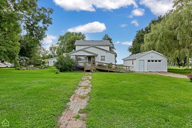 view of front facade with an outbuilding, a front yard, a wooden deck, and a garage