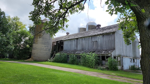 view of front of property featuring a front lawn, an outdoor structure, and a barn