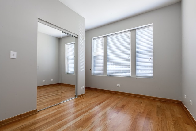 unfurnished bedroom with light hardwood / wood-style flooring and a closet