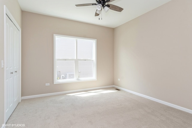 unfurnished bedroom with ceiling fan, light colored carpet, and a closet