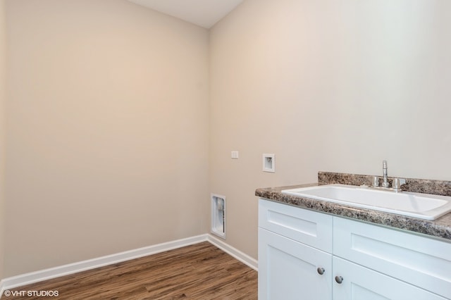 washroom featuring sink, hookup for an electric dryer, cabinets, dark hardwood / wood-style floors, and hookup for a washing machine