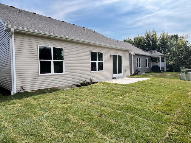 back of property featuring a lawn and a patio area