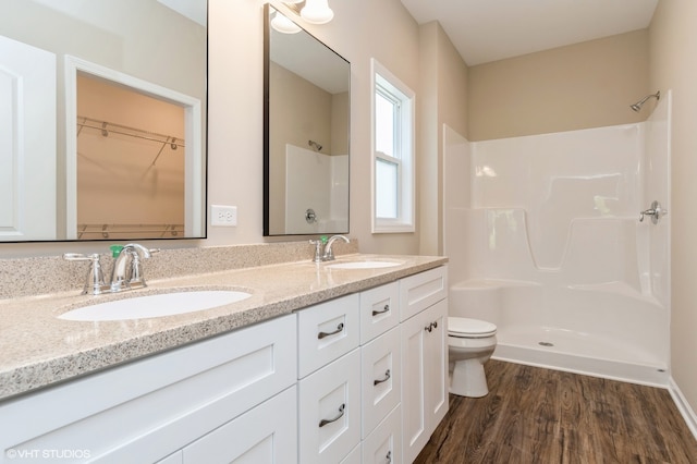 bathroom featuring vanity, a shower, toilet, and hardwood / wood-style flooring