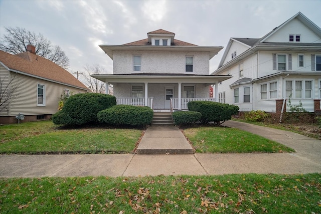 view of front of property featuring covered porch and a front yard