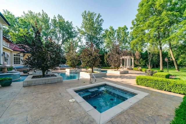 outdoor pool with a patio area and an in ground hot tub