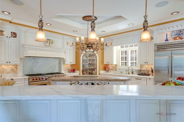 kitchen featuring a kitchen island, a tray ceiling, glass insert cabinets, white cabinetry, and high quality appliances