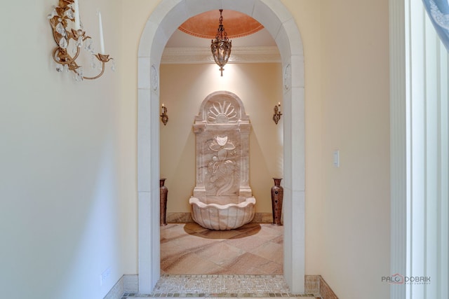 hallway with arched walkways and crown molding