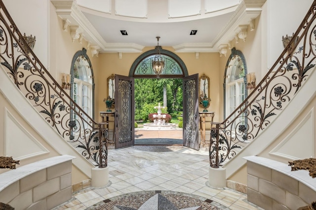 foyer entrance featuring stairs and crown molding