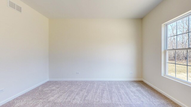 carpeted spare room featuring plenty of natural light