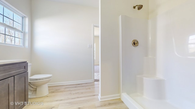 bathroom with vanity, toilet, hardwood / wood-style floors, and a shower