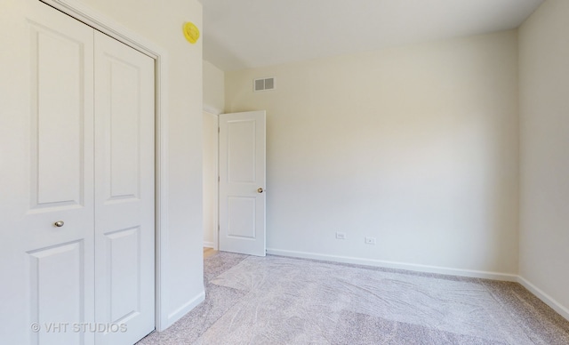 unfurnished bedroom with light carpet and a closet