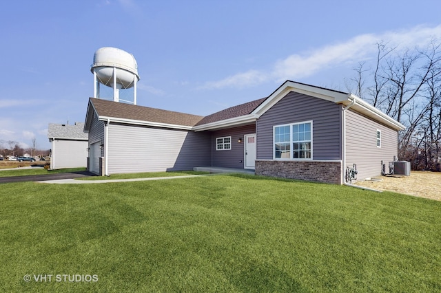 view of front of house with cooling unit, a garage, and a front lawn