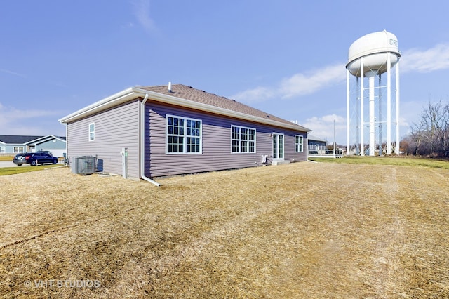 rear view of house featuring a yard and central air condition unit