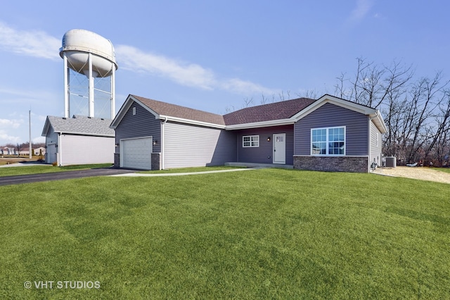 view of front of house featuring a garage, central air condition unit, and a front lawn