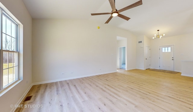 unfurnished room featuring ceiling fan with notable chandelier, vaulted ceiling, and light wood-type flooring