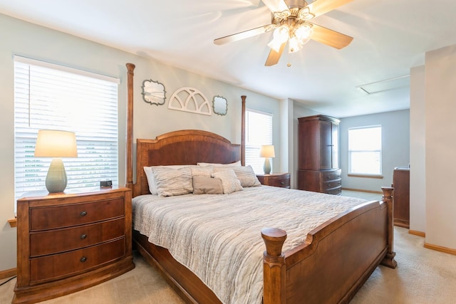 bedroom with light colored carpet, baseboards, and multiple windows