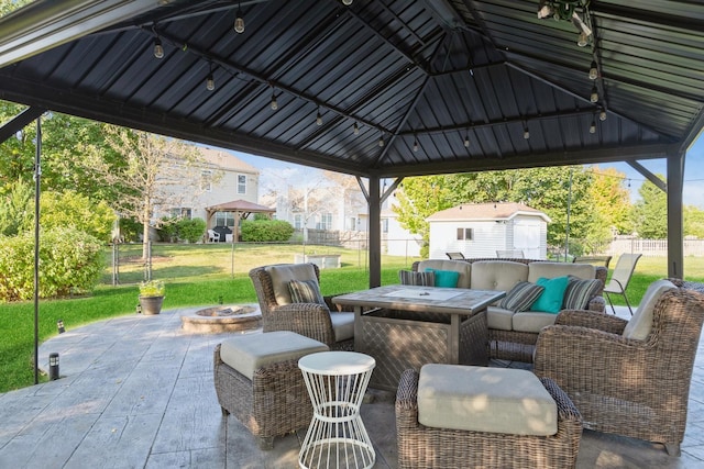 view of patio featuring an outdoor living space with a fire pit, fence, and a gazebo