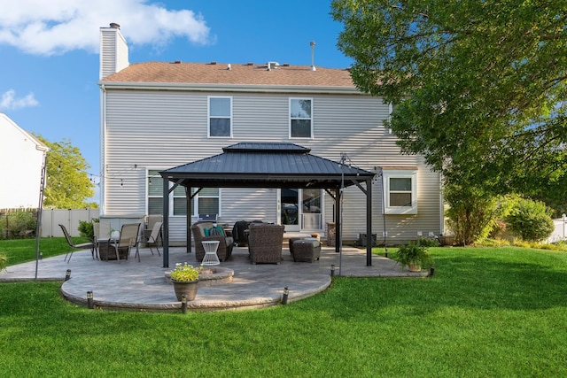 rear view of house with a yard, a chimney, a gazebo, a patio area, and fence