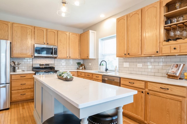 kitchen featuring light brown cabinets, appliances with stainless steel finishes, light countertops, and a sink