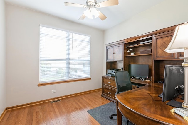 office space featuring baseboards, a ceiling fan, visible vents, and light wood-style floors