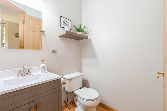 bathroom featuring wood finished floors, vanity, toilet, and baseboards