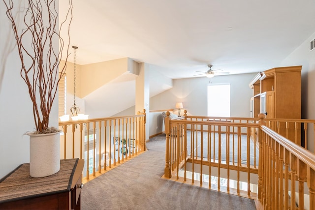 hallway featuring carpet flooring, visible vents, and an inviting chandelier