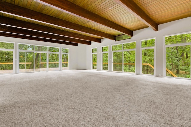 unfurnished living room featuring carpet, wooden ceiling, and beam ceiling